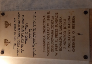 tablica informacyjna na temat losów synagogi w języku polskim i hebrajskim